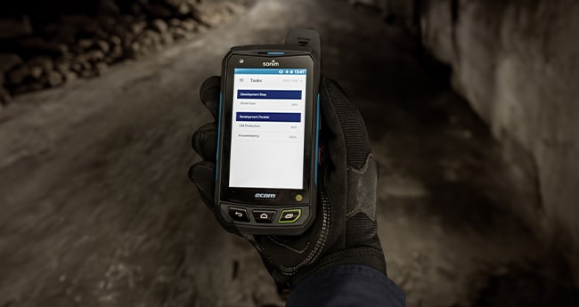 Man holding ProdMate tablet in an underground coal mine